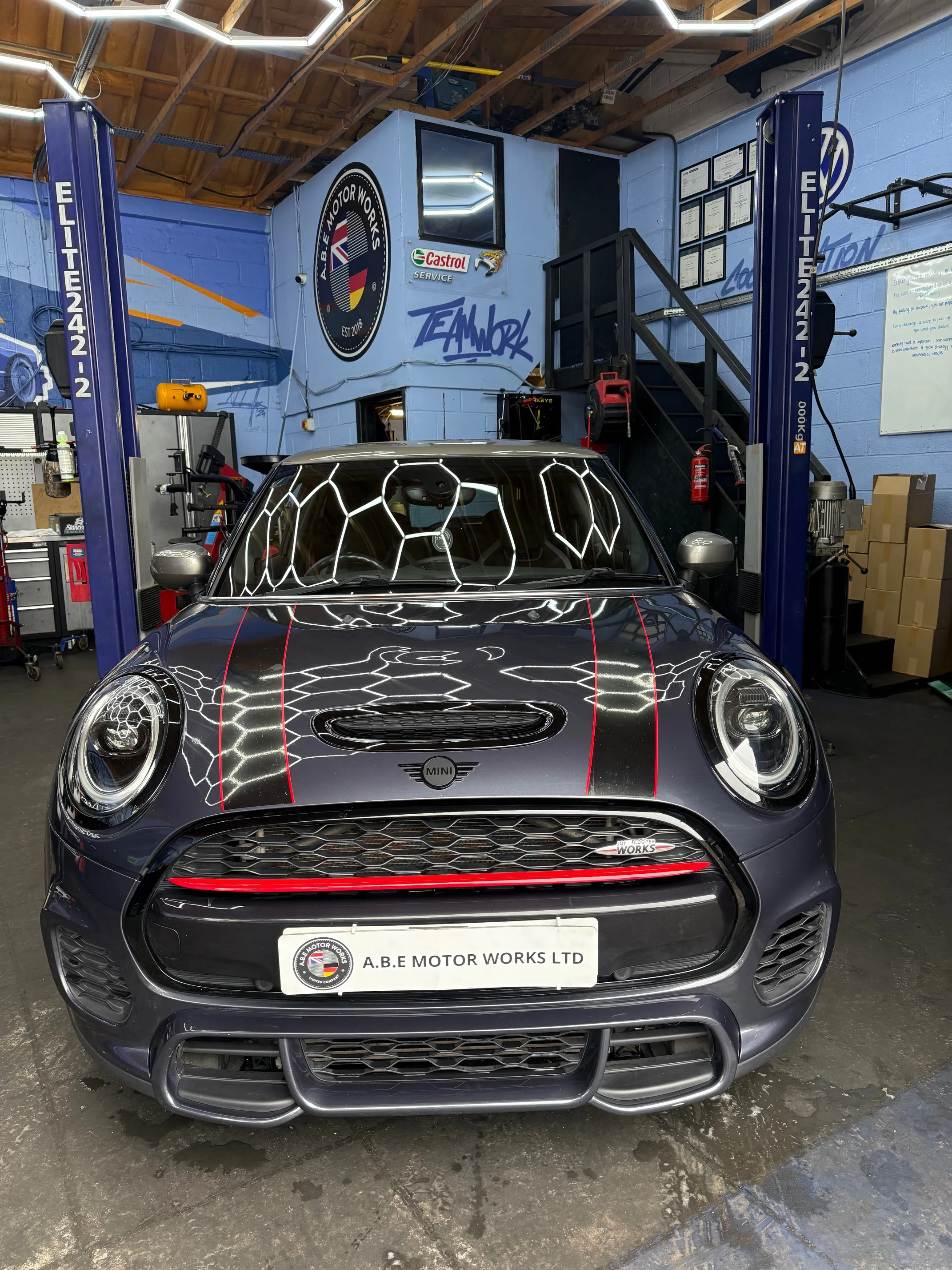 A car parked in a garage with a lot of work on it.