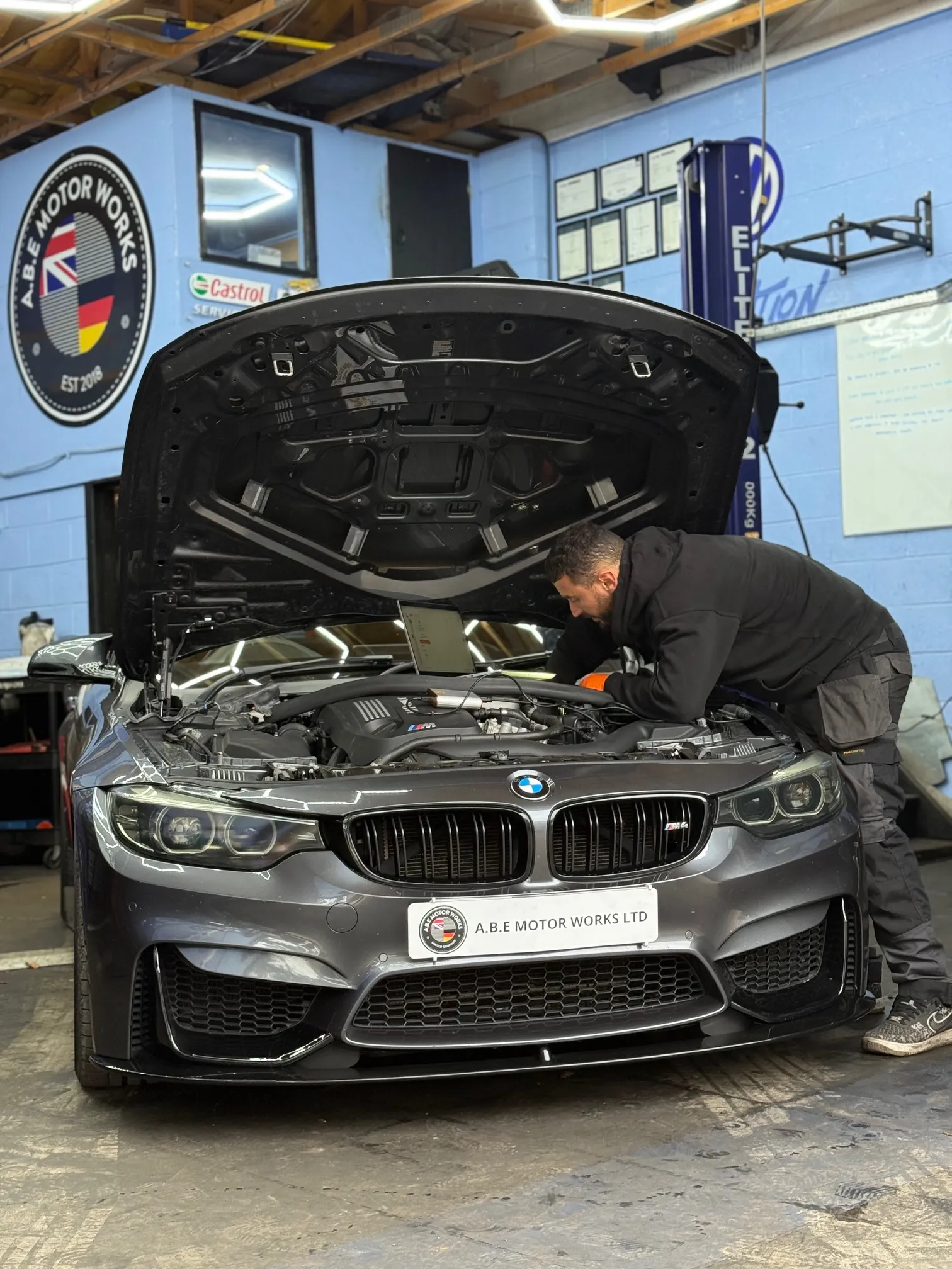 A man working on a car in a garage.